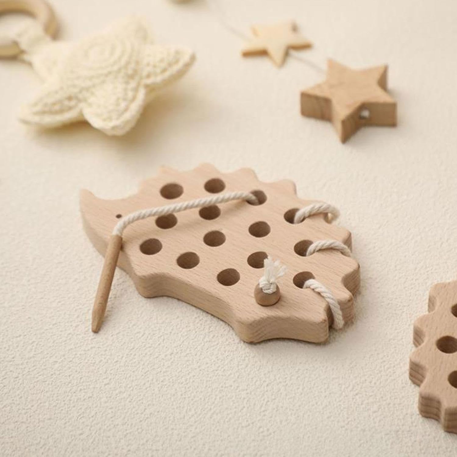 Wooden hedgehog threading toy beside wooden star toys in a Montessori nursery setting